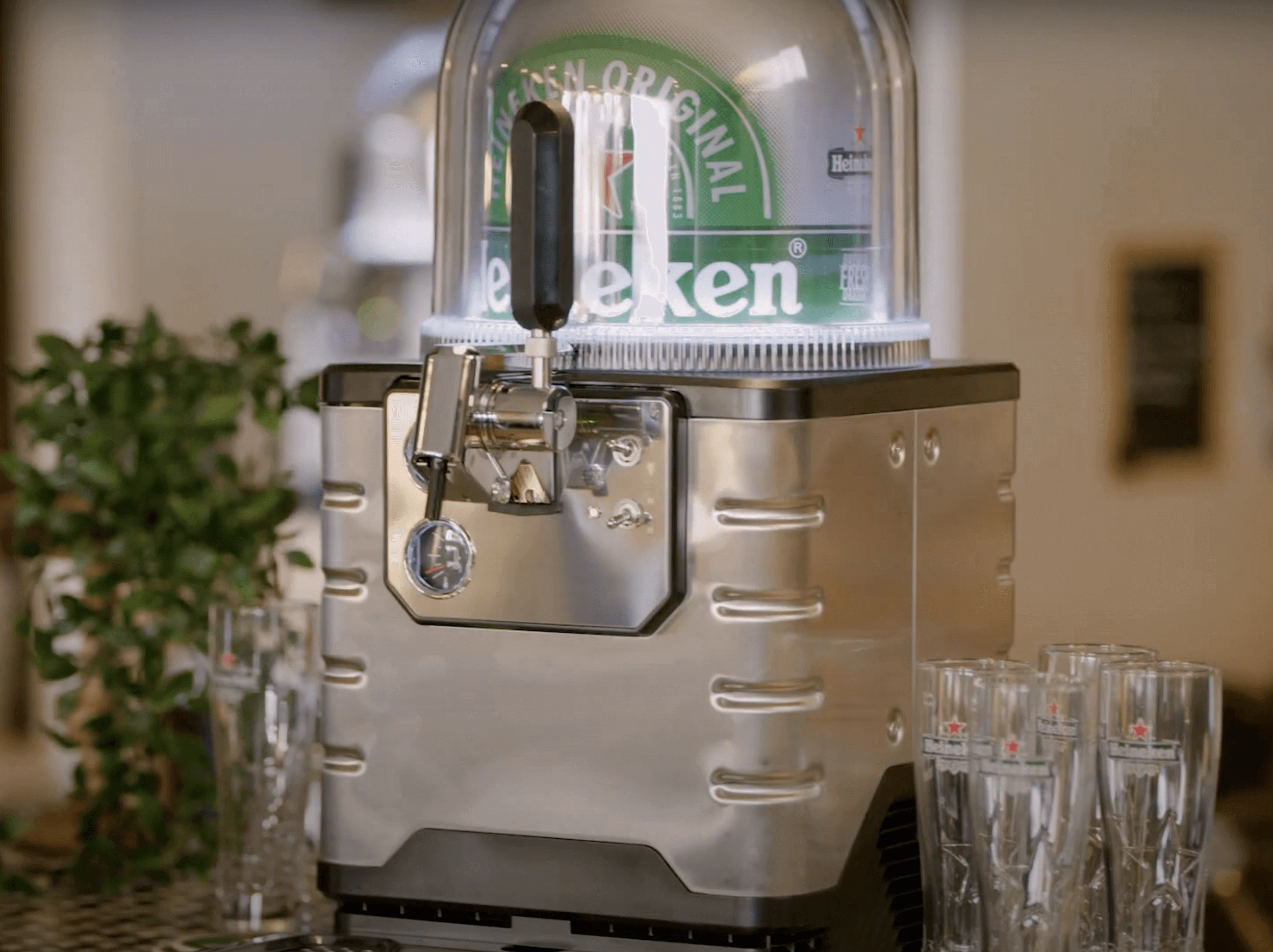 A BLADE beer machine loaded with a Heineken keg and surrounded by five Heineken beer glasses.