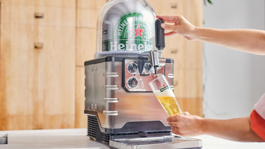 A Heineken beer being poured from a BLADE beer machine into a Heineken glass.
