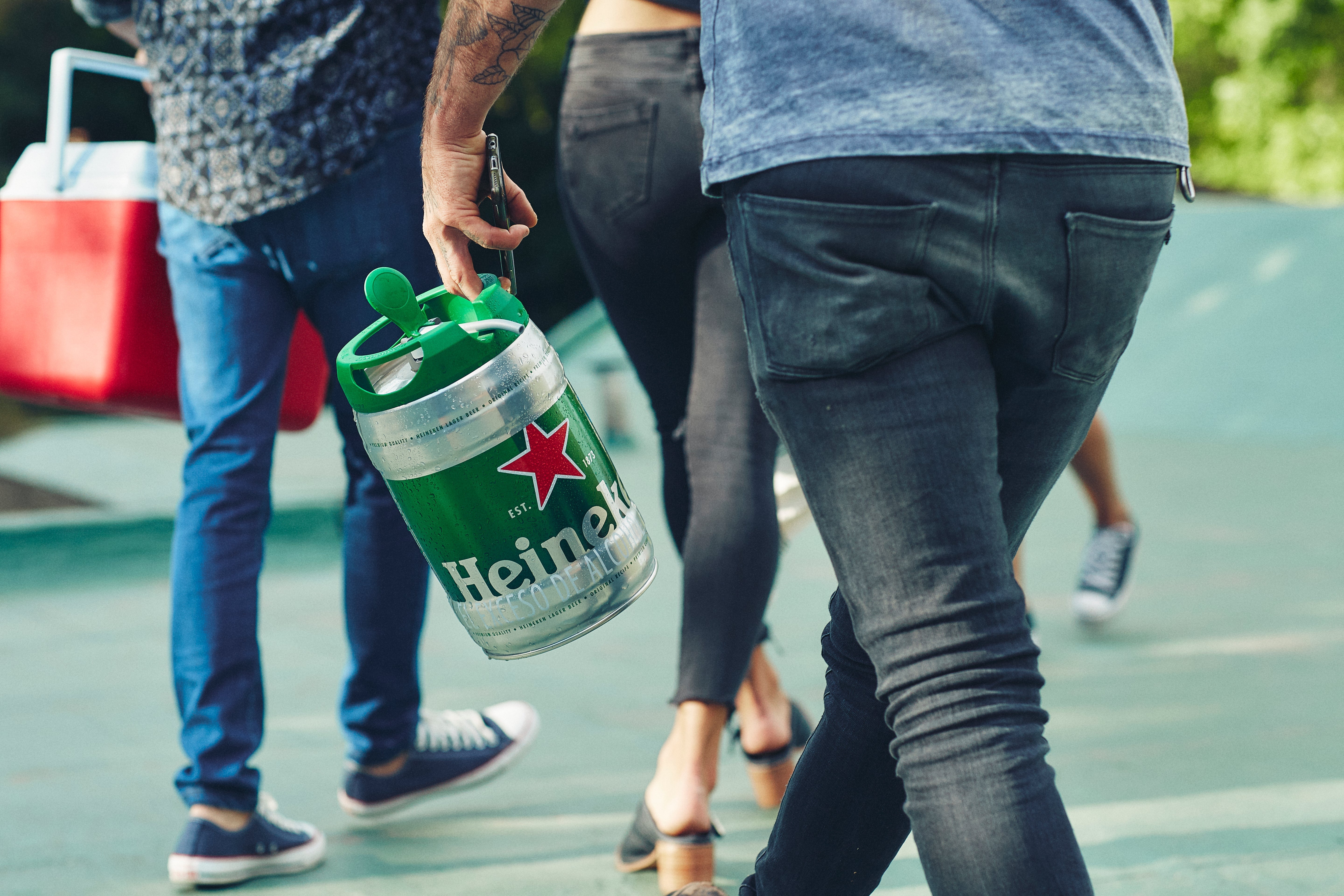 Person carrying a Heineken keg.