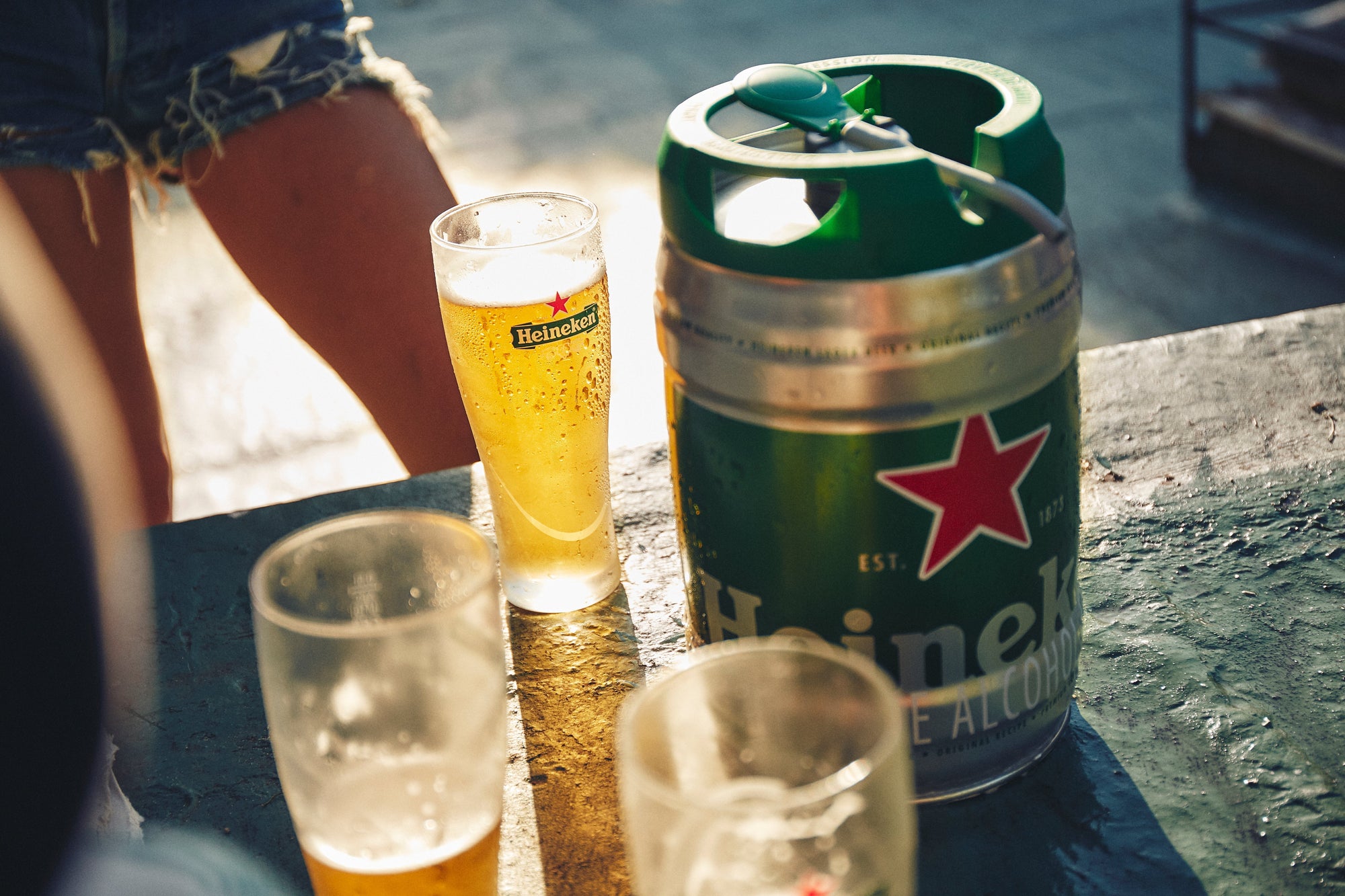 Heineken keg and glasses on a table outdoors
