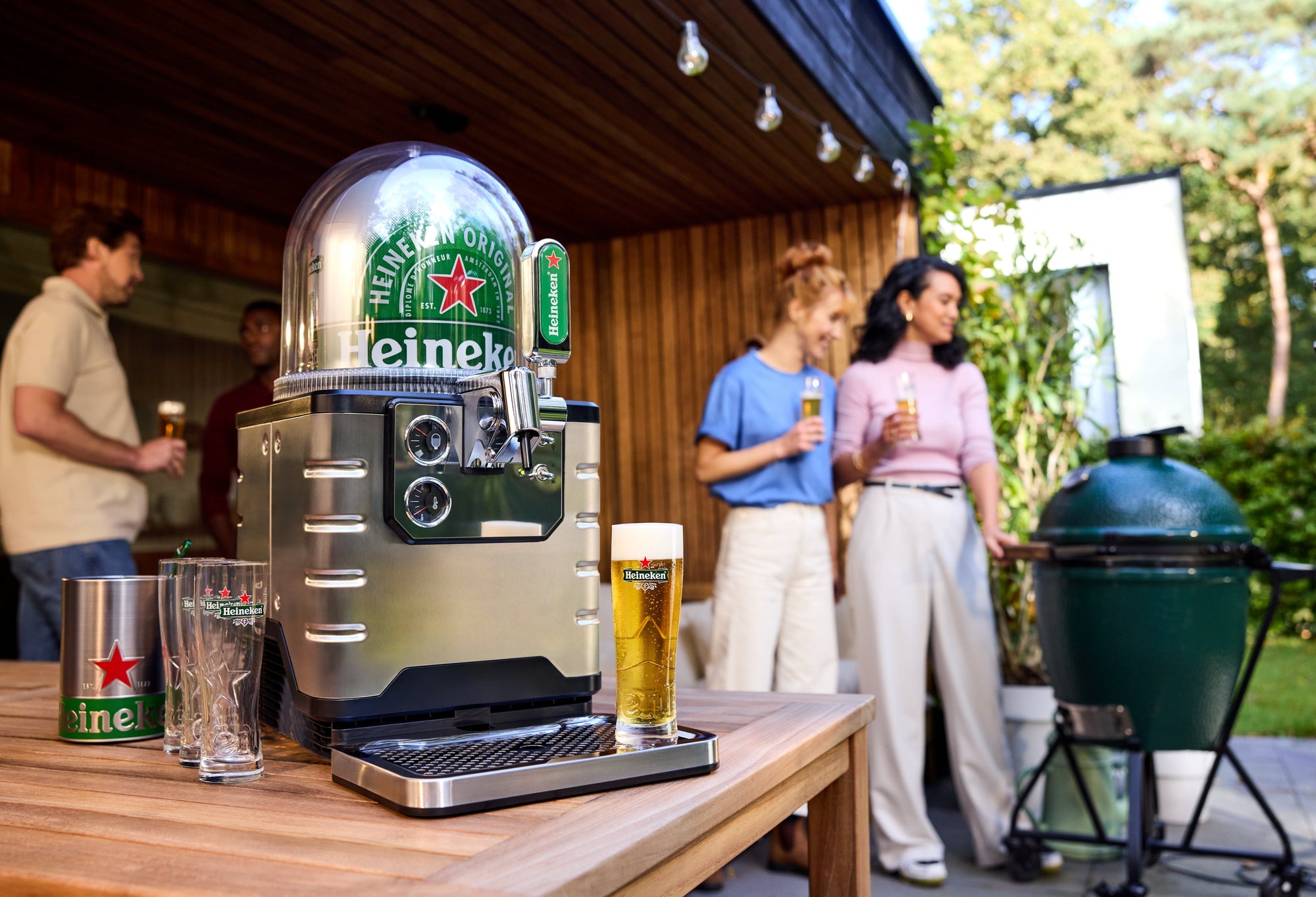 A BLADE beer machine on a table outdoors with people in the background