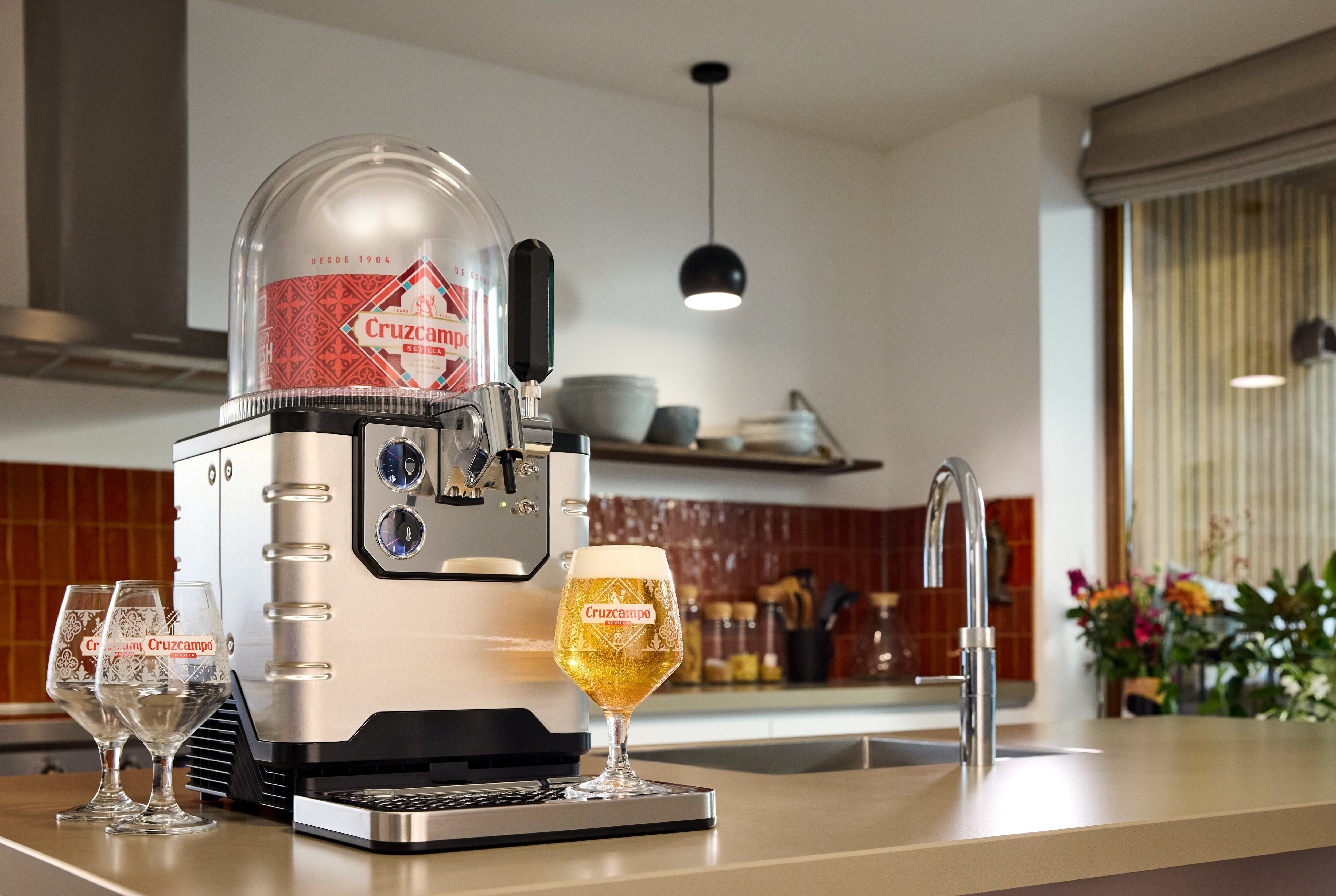 BLADE beer system on a kitchen counter with a glass of beer and glasses.
