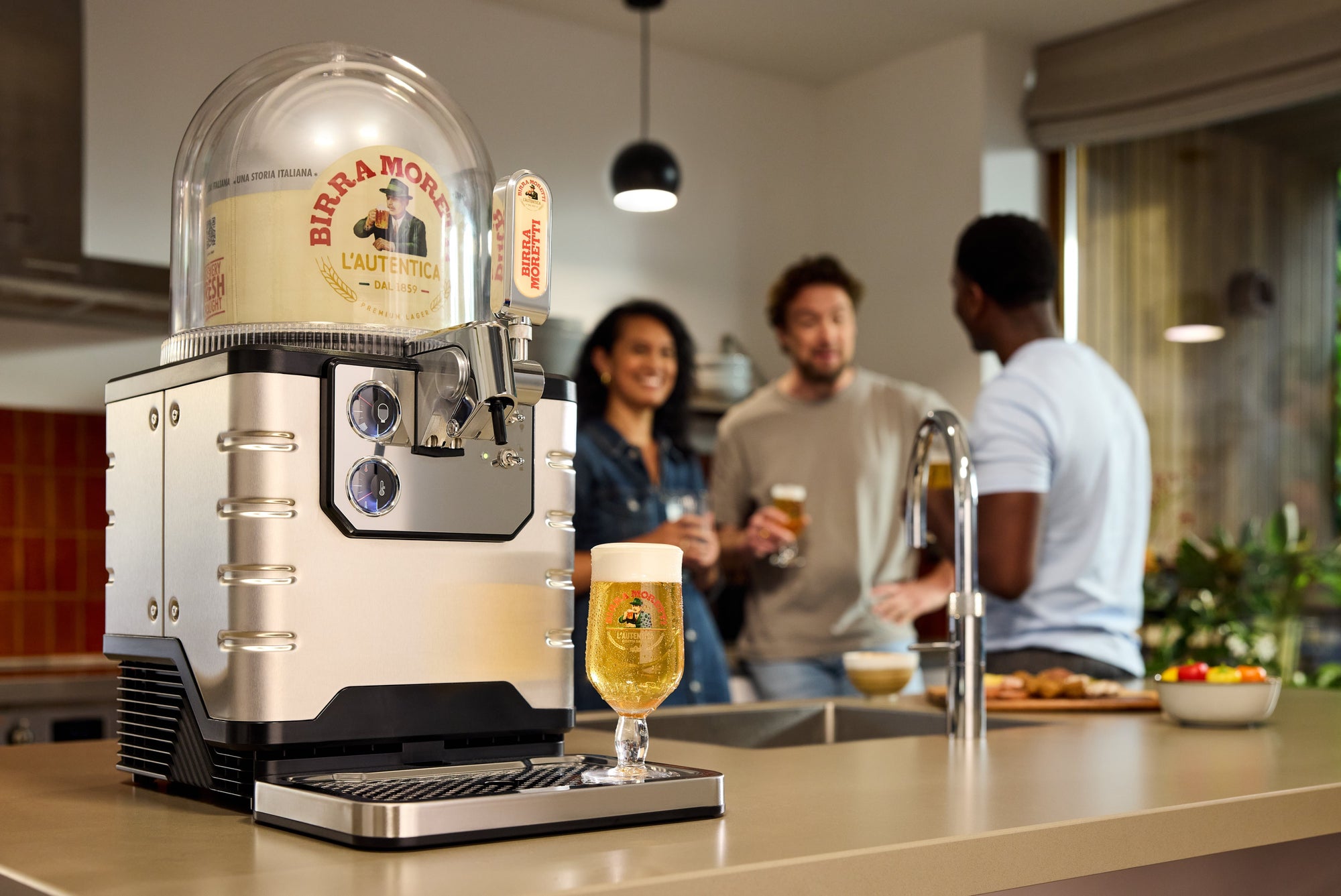 BLADE Biermaschine auf einer Küchentheke mit Leuten im Hintergrund