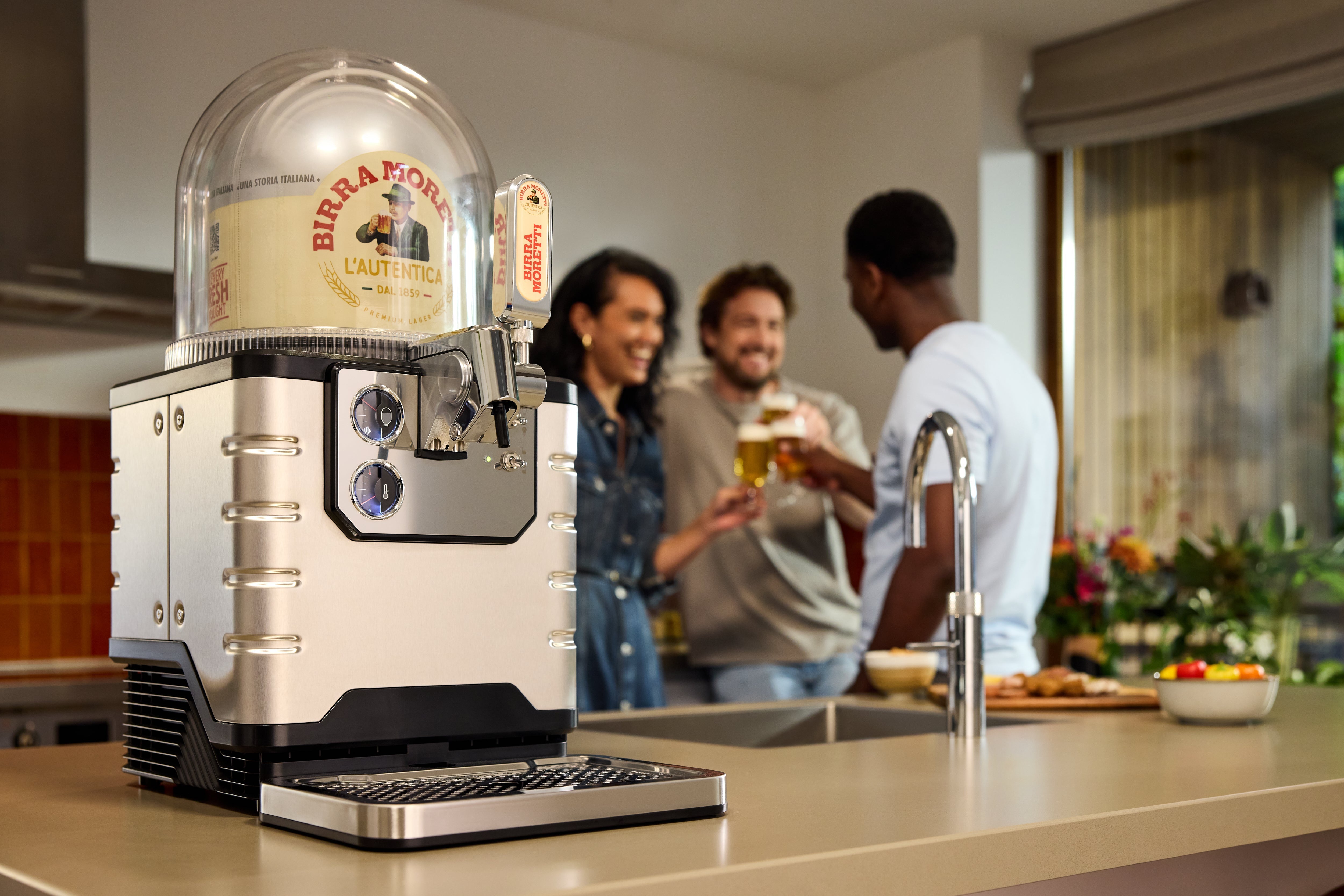 Une machine BLADE posée sur un plan de travail de cuisine, avec des personnes en arrière-plan