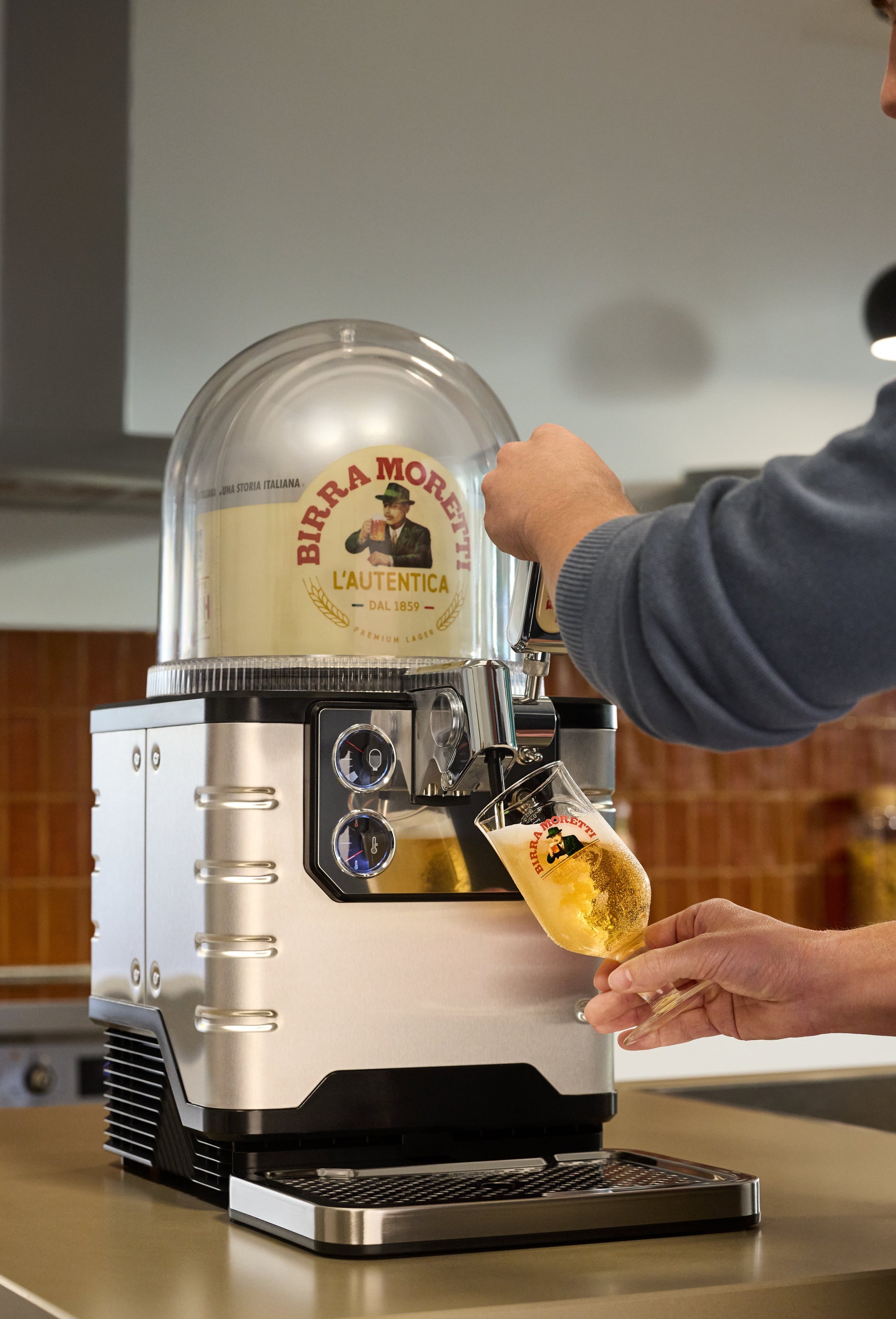 Person using a BLADE beer machine in a kitchen setting