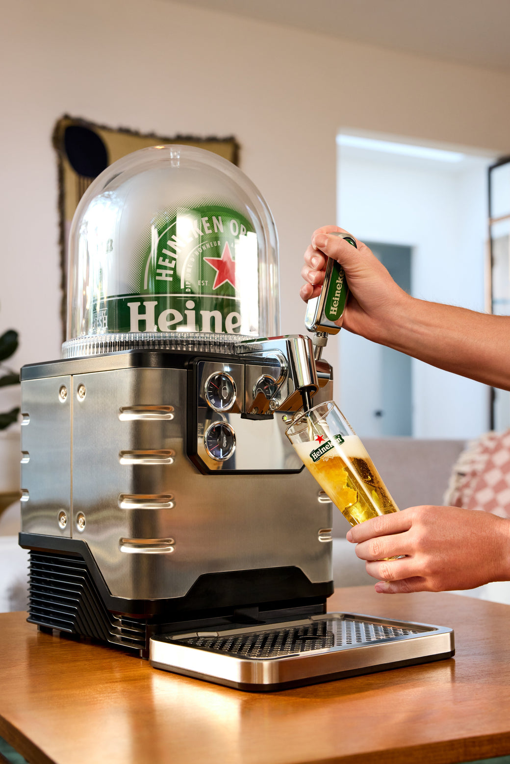 Person pouring Heineken beer from a BLADE beer tap into a glass.