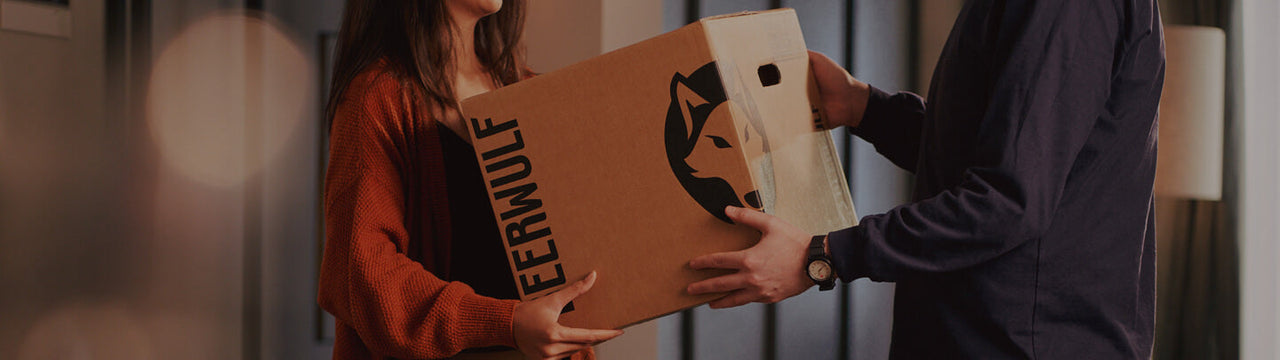 A Beerwulf box being exchanged between a man and a woman.