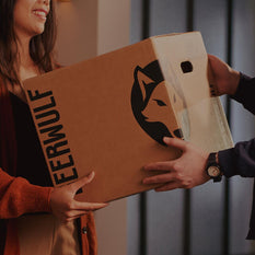 A Beerwulf box being exchanged between a man and a woman.