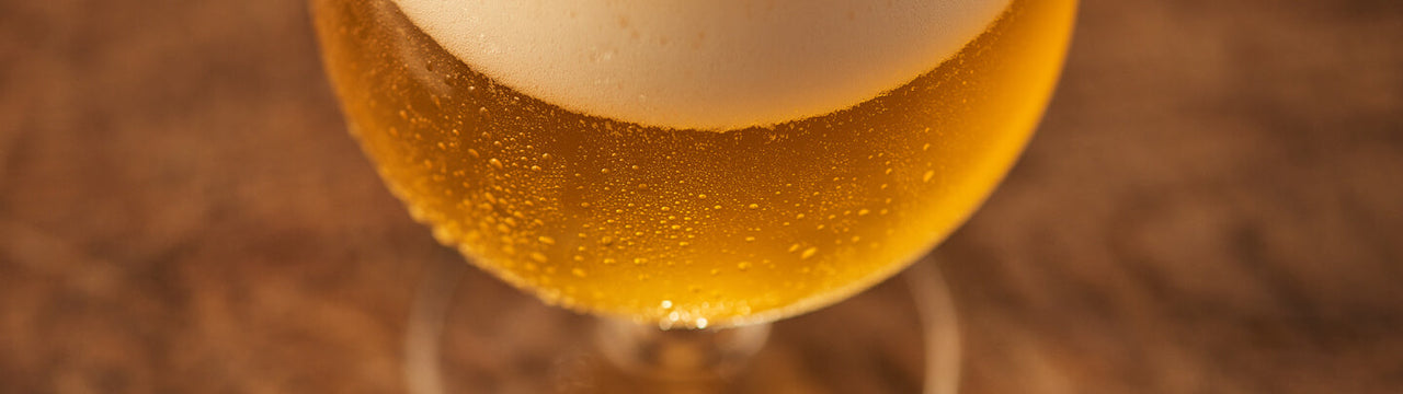 A freshly poured glass of beer with a large foam head.