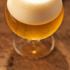 A freshly poured glass of beer with a large foam head.