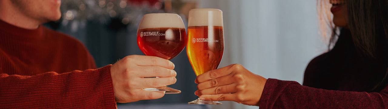 Two hands cheers with freshly poured glasses of amber coloured beer in Beerwulf beer glasses.