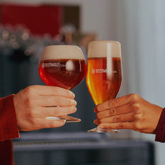 Two hands cheers with freshly poured glasses of amber coloured beer in Beerwulf beer glasses.