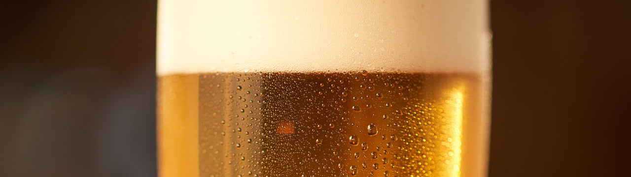 Close up of an ice cold lager beer with foam