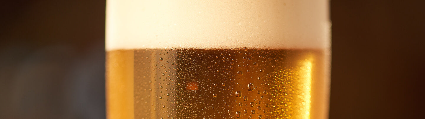 Close up of an ice cold lager beer with foam